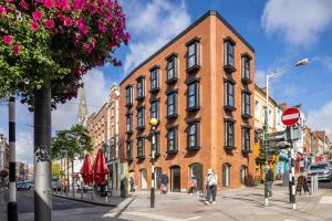 a large brick building on a city street with people walking past it at 3rd Floor Stylish 2-Bed Apartment in Drogheda
