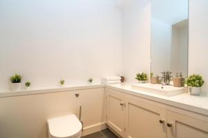 a bathroom with a sink and a toilet and a mirror at Buckingham Suite - Heart of Covent Garden! in London +43 photos