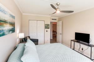 une chambre avec un lit et une télévision à écran plat dans l'établissement 8 Mi to Beach Modern Condo in Fort Myers!, à Fort Myers