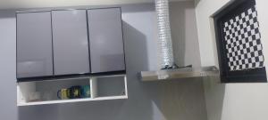 a kitchen with a glass cabinet with a light on it at Florida sun condo in Manggahan