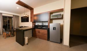 a kitchen with a refrigerator and a microwave at Hotel Zuma Colony in Querétaro