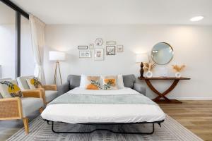 a bedroom with a bed and a chair and a mirror at Waikiki Banyan Fabulous Ocean View Condo with Free Parking in Honolulu