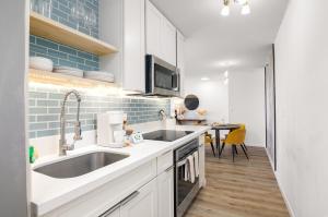 a kitchen with white cabinets and a sink at Waikiki Banyan Fabulous Ocean View Condo with Free Parking in Honolulu