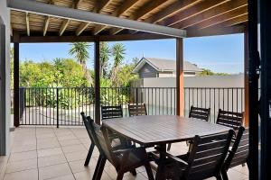 a porch with a wooden table and chairs on a patio at Ocean views in Buddina