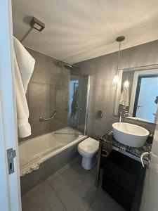 a bathroom with a sink and a tub and a toilet at YOO Punta del Este in Punta del Este