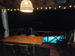 a wooden table in a room with chairs and a light at Cabaña Panambi in Villa Serrana