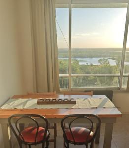 a table with two chairs in front of a large window at Terrazas de la Colina in Victoria