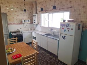 a kitchen with a white refrigerator and a table at Encanto en el centro salteño in Salta
