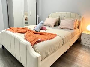 a large white bed in a room with a mirror at Chachino Guesthouse -5 Mins walk to Train & Bus Station in Agualva