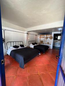 a room with two beds and a red floor at Los Cruxes in Tepoztlán