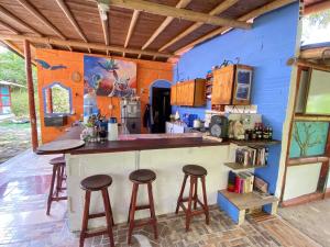 une cuisine avec un comptoir et des tabourets dans un mur bleu dans l'établissement Habitación de pareja con desayuno incluido y acceso al rio, à San Carlos