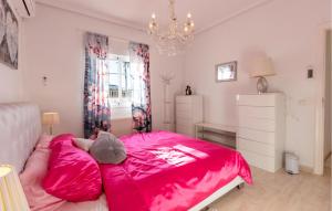 ein Schlafzimmer mit einem rosa Bett und einem Kronleuchter in der Unterkunft 3 Bedroom Cozy Home In Rojales in Rojales