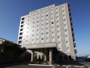 a large white building with a sign on it at Hotel Route-Inn Uozu in Uozu