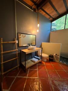 a bathroom with a sink and a toilet in a room at Los Cruxes in Tepoztlán