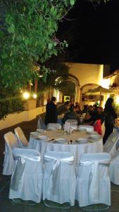 a group of people sitting around a table with white chairs at Hacienda Dolores Ñadó, Aculco in Los González +31 photos