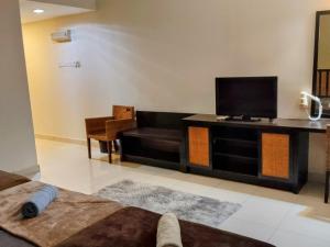 Una televisión o centro de entretenimiento en Sunset studio apartment Goldcoast morib 1 fotos más
