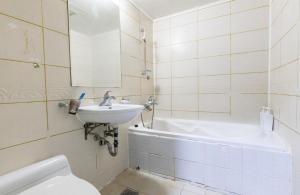 Un baño con lavabo, bañera e inodoro. en City Motel, en Hanam