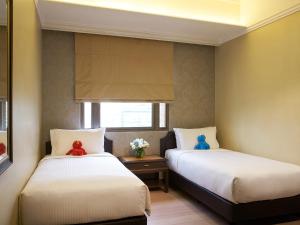 a bedroom with two beds and a window at Orchard Parksuites by Far East Hospitality in Singapore