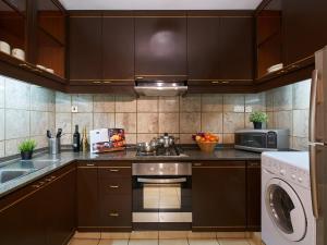 a kitchen with brown cabinets and a stove top oven at Orchard Parksuites by Far East Hospitality in Singapore