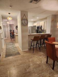 a kitchen and living room with a clock on the wall at D&T Flamingo Paradise in Haines City