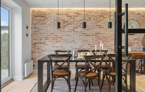 a dining room with a brick wall and a table and chairs at Cozy Home In Thyborøn With Wifi in Thyborøn