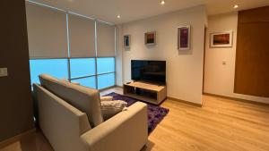a living room with a couch and a television at MD Zamora Condesa in Mexico City