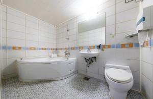 Un baño con bañera, inodoro y lavabo. en City Motel, en Hanam
