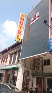 a store with a sign on the side of a building at Axis Hotel in Taiping