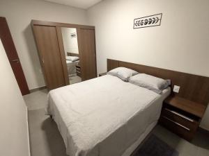 um quarto com uma cama grande e um espelho em Residencial Verônica 06 - Apartamento de 1 quarto próximo ao centro em Marília mais 5 fotografias