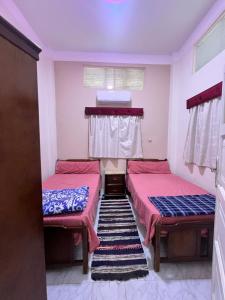 una habitación con dos camas y una ventana en Cozy airconditioned two bedroom apartments شقق فندقية مكيفة للإيجار, en Ras El Bar