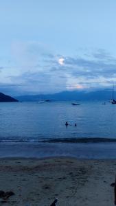 a group of people in the water on a beach at Suites com vista para o Mar in Angra dos Reis