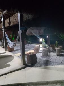 a patio at night with a hammock and a building at Suites com vista para o Mar in Angra dos Reis +4 photos
