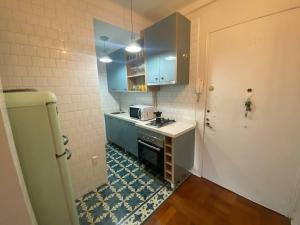 a small kitchen with blue cabinets and a stove at Vintage Apartment Lastarria in Santiago +10 photos