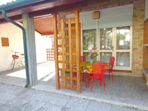 圣玛格丽塔波尔勒港Villa in Caorle near Spiaggia Tartaruga的露台上摆着桌子和椅子