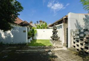 une cour d'une maison avec une fontaine dans l'établissement Gemstones Villa, à Seminyak