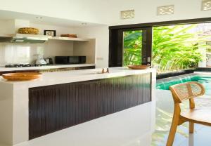 un îlot dans une cuisine avec piscine dans l'établissement Gemstones Villa, à Seminyak