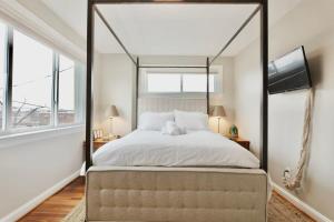 ワシントンにあるYour Happy Place Entire Home - With Parkingのベッドルーム1室(天蓋付きベッド1台、大きな窓付)