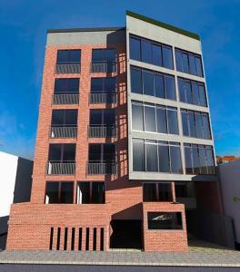 a tall brick building with a lot of windows at Departamento Casa Romita in San Antonio Quintanilla