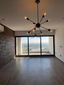 a large room with a chandelier and a large window at Departamento Casa Romita in San Antonio Quintanilla