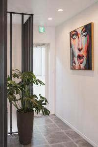 a plant in a hallway with a painting on the wall at INFINITY HOTEL -Higawa- in Naha
