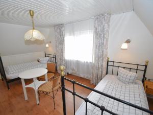 Un dormitorio con una cama y una mesa y una mesa y sillas. en Cottage in Neuastenberg near the ski area, en Winterberg