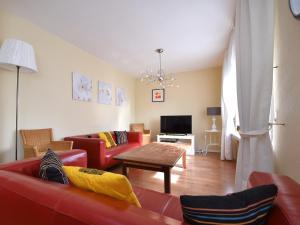 Una sala de estar con sofás rojos y una mesa. en Cottage in Neuastenberg near the ski area, en Winterberg
