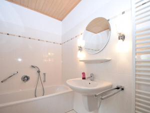 Un baño blanco con lavabo y espejo. en Cottage in Neuastenberg near the ski area, en Winterberg 32 fotos más