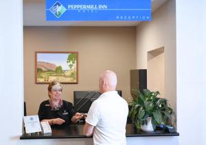 a man and a woman standing at a reception desk at Peppermill Inn Motel in Shepparton +33 photos