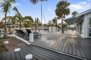 a wooden deck with chairs and a building at Adventure at Siesta Key Beach & Sandbar Escape in Sarasota