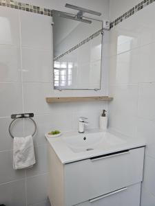 a white bathroom with a sink and a mirror at Perle proche gare maritime et croisières in Pointe-à-Pitre
