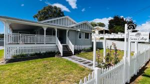 a white fence in front of a house at Savina Cottage in Stanthorpe