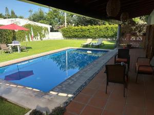 - une piscine dans une cour avec des chaises et un parasol dans l'établissement Casa nueva en Lomas de Cocoyoc, alberca climatizada, PET friendly, à Texcalpan