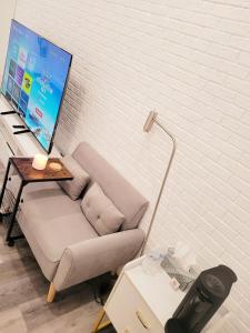 a living room with a couch and a tv on a wall at Private studio guesthouse in Watertown CT in Watertown