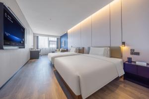 Televiisor ja/või meelelahutuskeskus majutusasutuses Atour Hotel Wefang High Tech Zone Management Committee East Jiankang Street